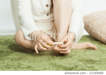 A young lady who takes care of the nail of the foot 21169986
