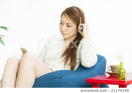 Pretty woman listening to music in the room 21170140