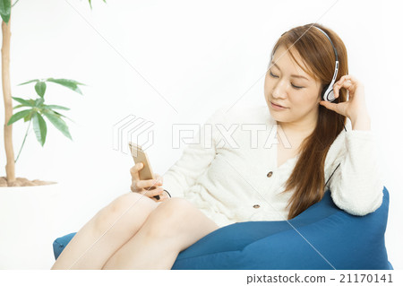 Pretty woman listening to music in the room 21170141