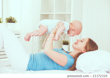 happy family mother playing  with baby in bed 21172320