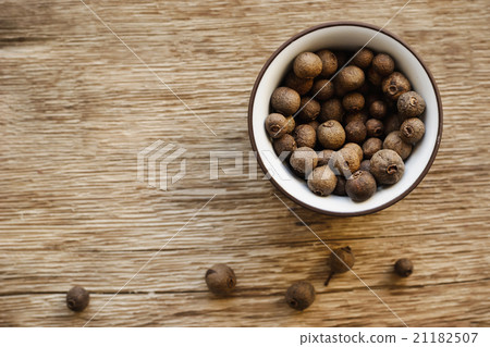 Allspice in the dish on the wooden background Allspice in the dish on the wooden background 21182507