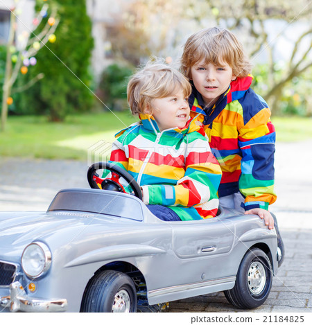 Two happy sibling boys playing with big old toy Two happy sibling boys playing with big old toy 21184825