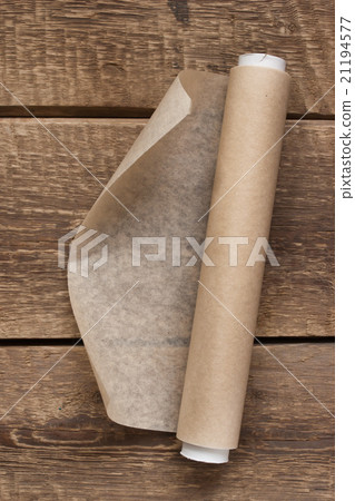 An open roll of paper on the wooden table 21194577