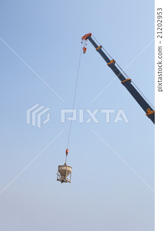 Crane lifting concrete mixer container against sky 21202953