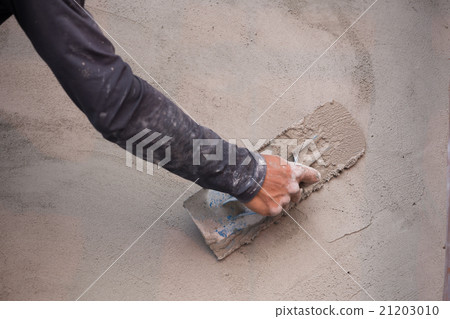 hand of worker use trowel plastering concrete wall 21203010