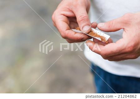 BATUMI - JULY 8: man makes a handmade cigarette BATUMI - JULY 8: man makes a handmade cigarette 21204862