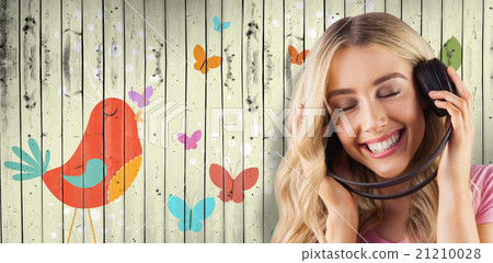 Composite image of a beautiful woman enjoying listening her music Composite image of a beautiful woman enjoying listening her music 21210028