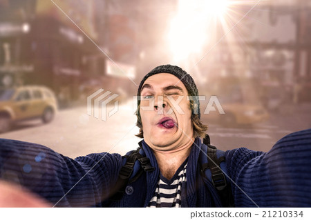 Composite image of hipster holding camera and grimacing Composite image of hipster holding camera and grimacing 21210334