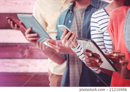 Composite image of smiling creative team standing in a line usin 21210986