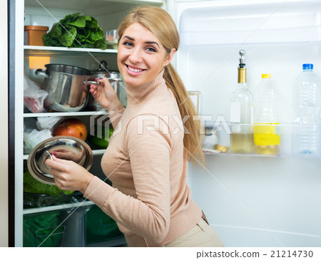 Satisfied housewife near filled fridge 21214730