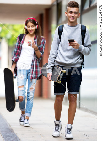 Teenage friends carrying skateboards in the city Teenage friends carrying skateboards in the city 21214778