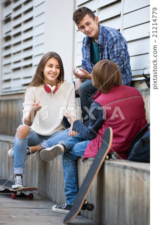 Three teenagers hanging out outdoors 21214779