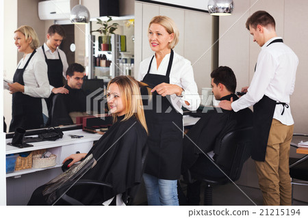 Smiling aged woman cutting girl hair 21215194
