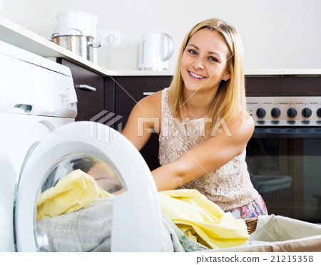 loading clothes into washing machine 21215358