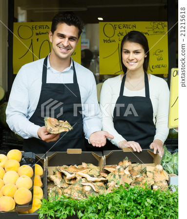 Salespeople with farm mushrooms in market, prices are on Spanish 21215618