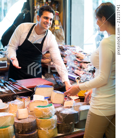 Portrait of seller offering different cheese Portrait of seller offering different cheese 21215741