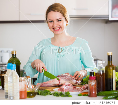 Young woman cooking lamb for dinner at home Young woman cooking lamb for dinner at home 21216071