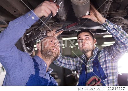 Two car mechanics at workshop 21216227