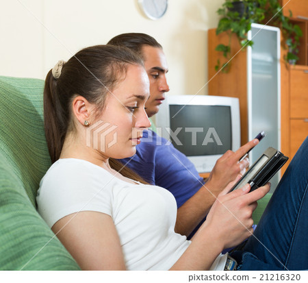 Couple reading eBooks at home. 21216320