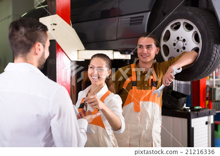 Female mechanic giving client keys Female mechanic giving client keys 21216336