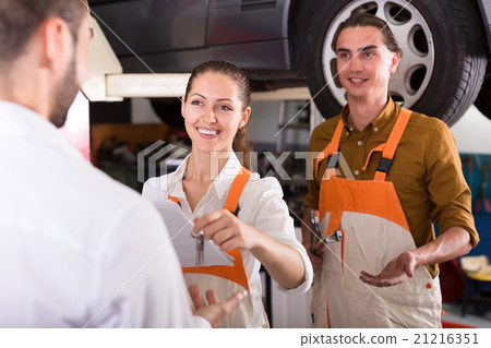 Mechanic giving keys from ready car Mechanic giving keys from ready car 21216351