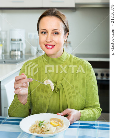 Woman eating at kitchen Woman eating at kitchen 21216379