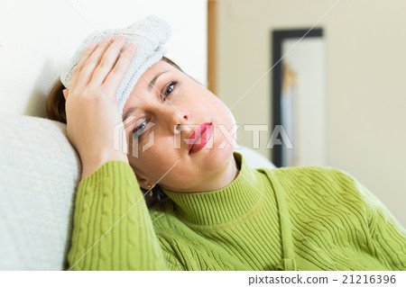 Female with wet towel on forehead Female with wet towel on forehead 21216396