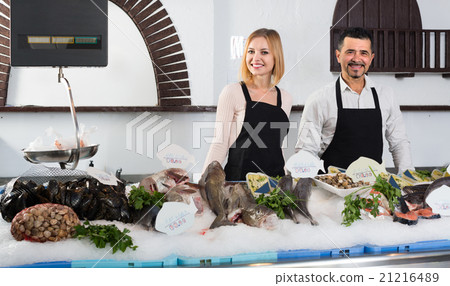 Two sellers in fish section of supermarket. Two sellers in fish section of supermarket. 21216489