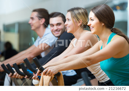 adults riding stationary bicycles in fitness club adults riding stationary bicycles in fitness club 21216672