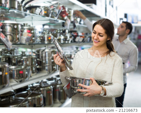 couple chooses pans in shop cookware 21216673