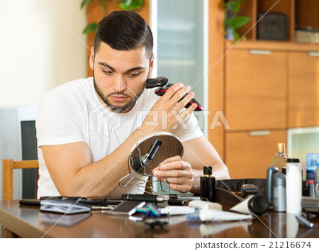 guy shaving by electric shaver 21216674