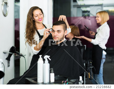 Happy hairdresser doing hairstyle 21216682