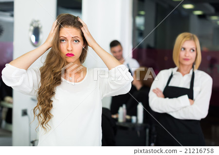 Displeased client and hairdresser. Displeased client and hairdresser. 21216758