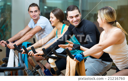 Active adults riding stationary bicycles Active adults riding stationary bicycles 21216760