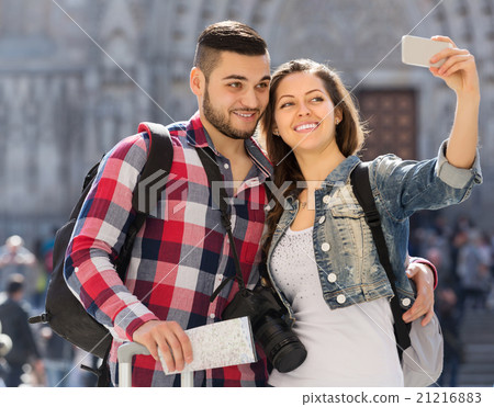 Couple with luggage doing selfie 21216883