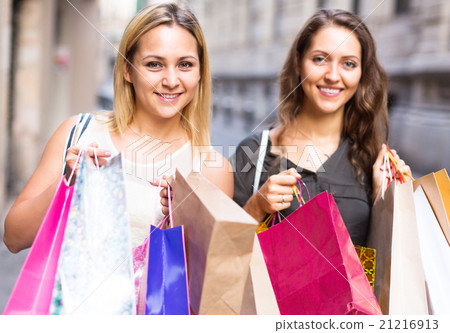 girls carrying bags with purchases 21216913
