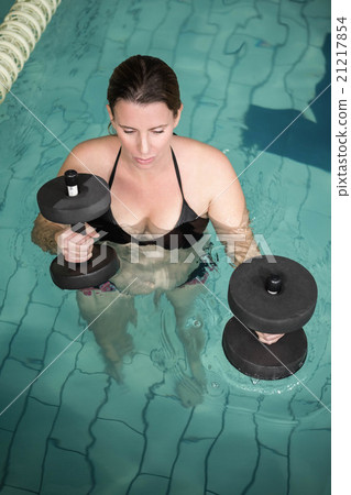 Happy pregnant woman exercising in the pool with weights 21217854