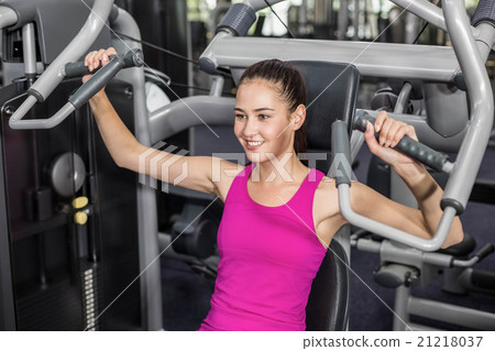 Fit woman using weight machine 21218037
