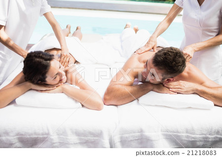 Young couple receiving a back massage from masseur Young couple receiving a back massage from masseur 21218083