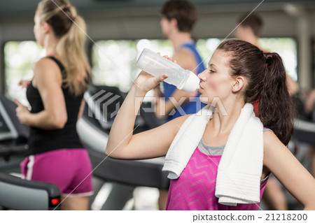 Fit woman posing while drinking 21218200