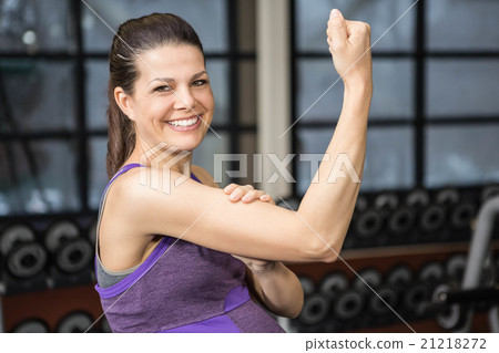 Smiling pregnant woman showing biceps 21218272