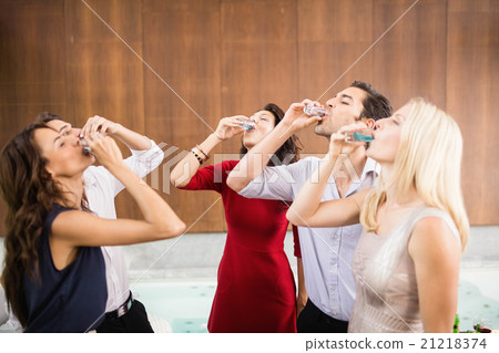 Young and handsome group of friends drinking shots Young and handsome group of friends drinking shots 21218374