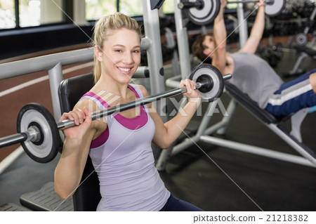 Fit woman lifting barbell Fit woman lifting barbell 21218382