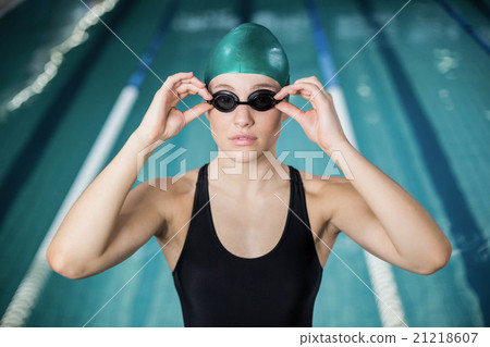 Woman in swimsuit adjusting her goggles Woman in swimsuit adjusting her goggles 21218607
