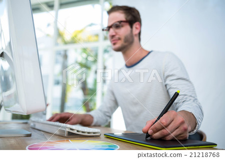 Handsome man working on computer and taking notes Handsome man working on computer and taking notes 21218768