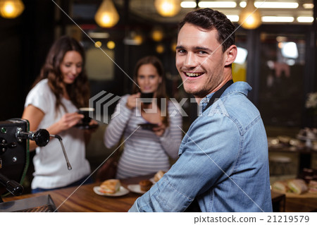 Smiling barista looking back at the camera 21219579