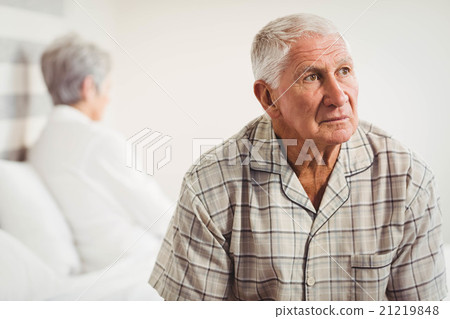 Upset senior man sitting on the opposite ends of the bed Upset senior man sitting on the opposite ends of the bed 21219848