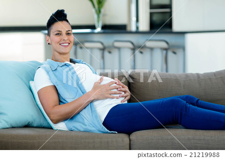 Portrait of pregnant woman relaxing on sofa 21219988