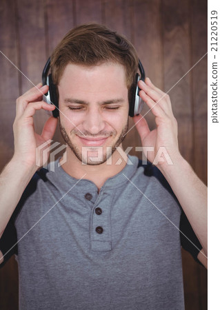 Handsome hipster listening to music with headphones 21220519