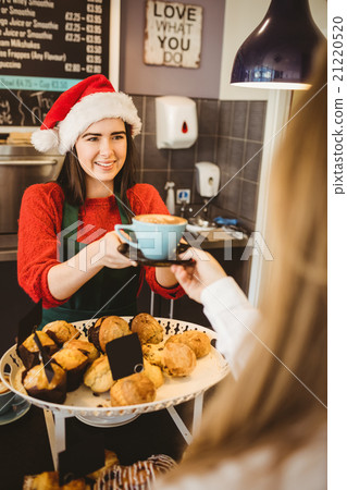 Cute waitress giving a coffee to customer Cute waitress giving a coffee to customer 21220520